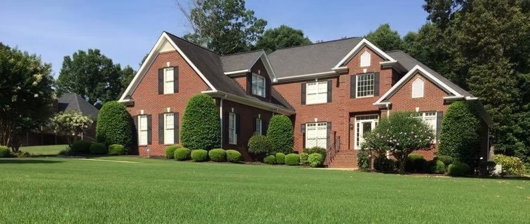 Lawn and landscaping beside a brick home